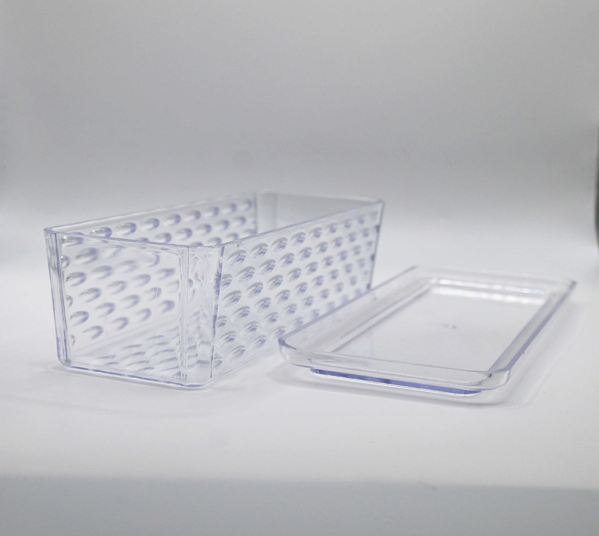 Angled view of clear textured container with lid beside it